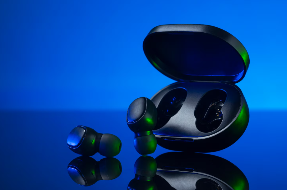 Premium wireless earbuds with charging case on reflective surface against blue background