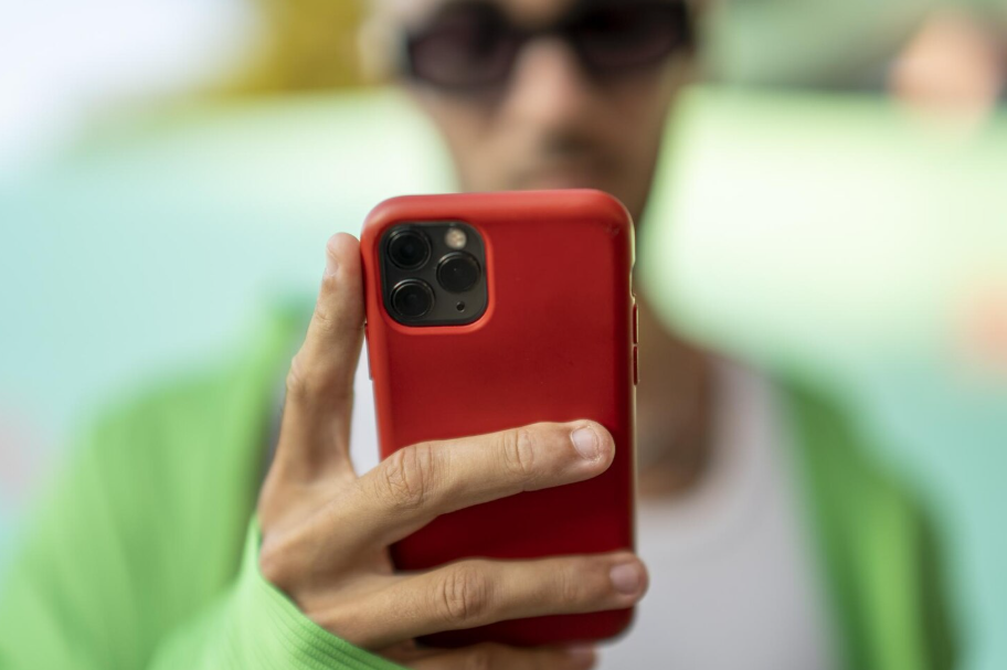 Person holding smartphone with red protective phone case