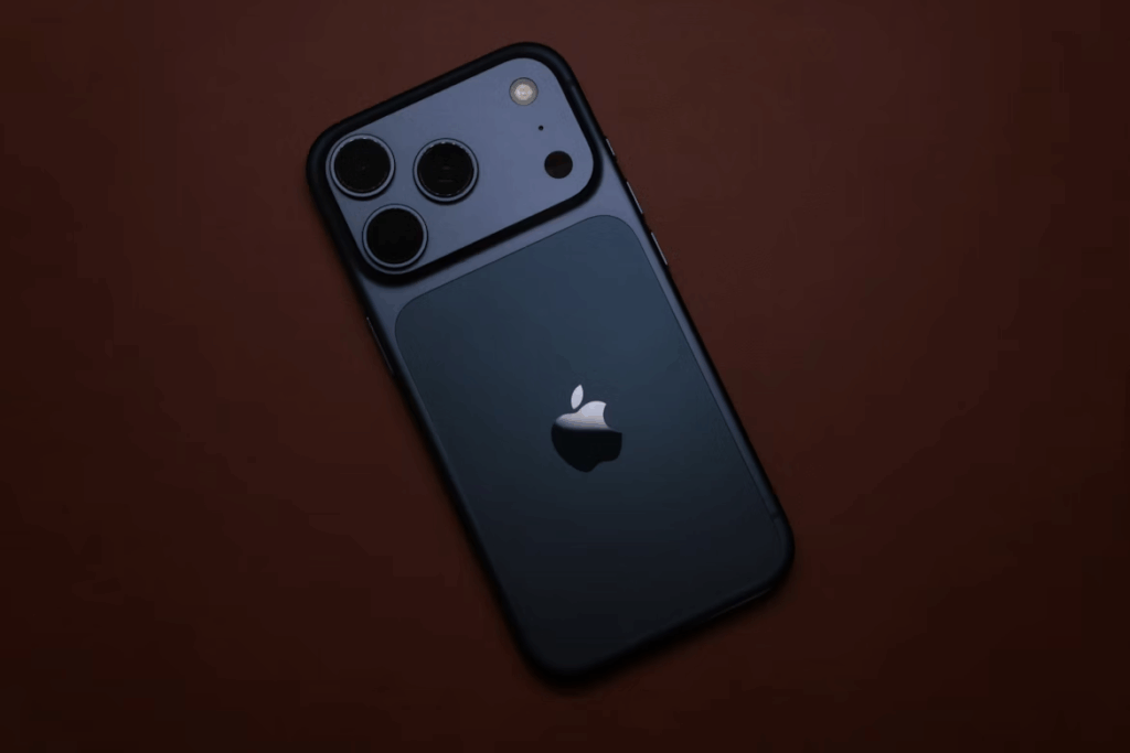 Close-up of the latest iPhone with triple camera system placed on a brown surface.