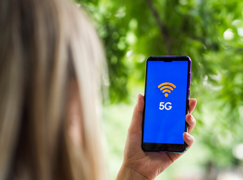 Smartphone displaying 5G connection in hand, showing benefits of 5G for speed