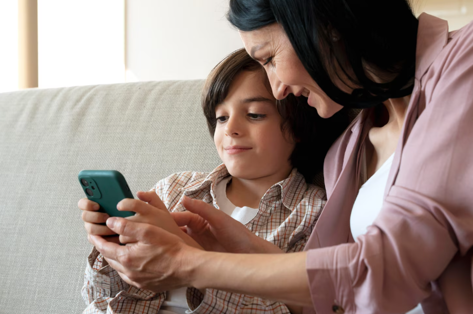 Mother helping her child set parental controls on a smartphone