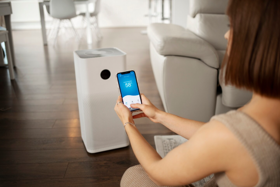 Woman using smartphone app to connect and control a smart home air purifier