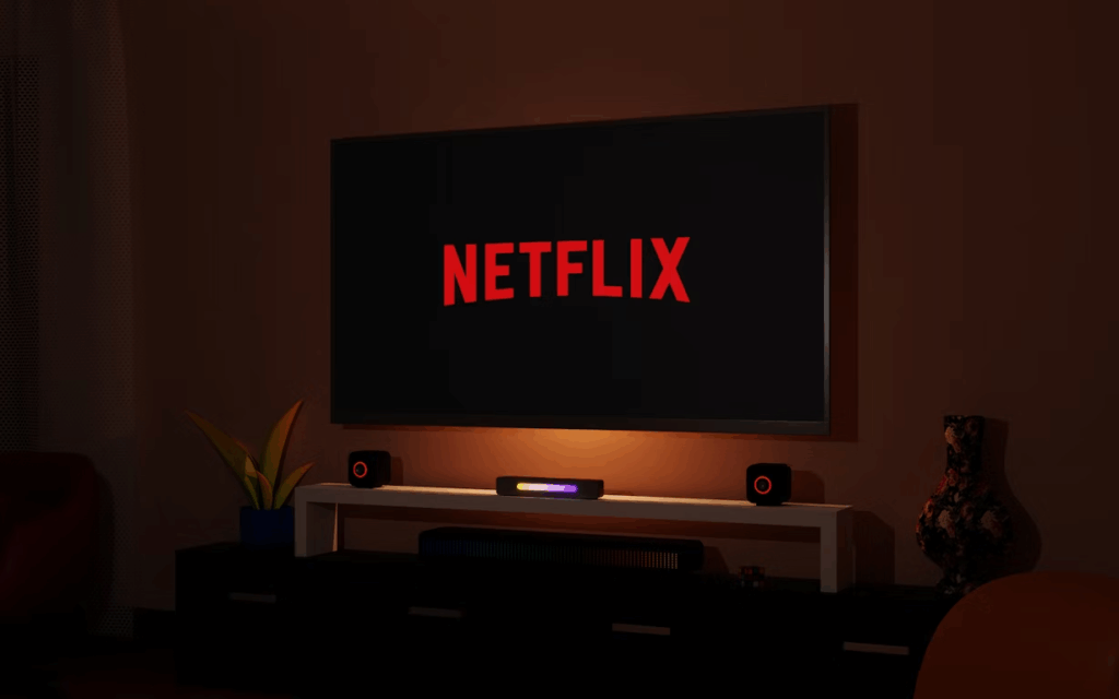 TV screen displaying Netflix logo in a dark living room setup