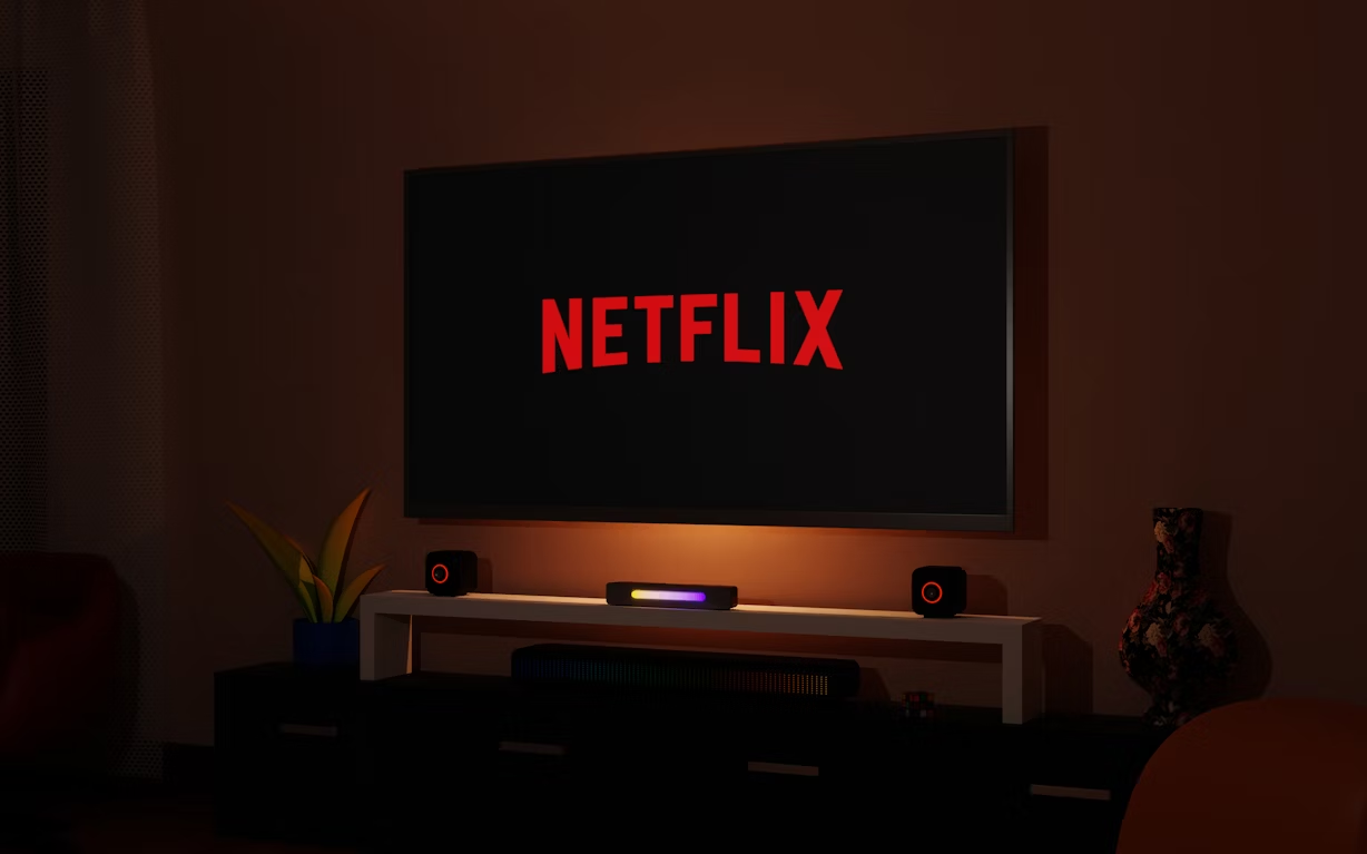 TV screen displaying Netflix logo in a dark living room setup